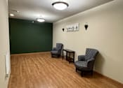 Thumbnail 14 of 34 - Two chairs and a table are in a room with wooden floors.