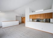 Thumbnail 48 of 60 - a kitchen and living room with white walls and wood cabinets