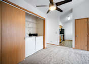 Thumbnail 31 of 60 - an empty room with a kitchen and a ceiling fan