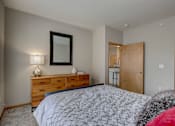 Thumbnail 25 of 64 - a bedroom with a bed and a dresser with a mirror