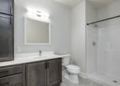 Thumbnail 13 of 18 - A bathroom with a white toilet and a white sink.