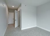 Thumbnail 12 of 18 - A room with a carpeted floor and two doors.