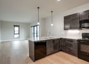Thumbnail 8 of 18 - A kitchen with dark wood cabinets and a white countertop.