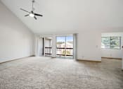 Thumbnail 33 of 60 - an empty living room with a ceiling fan and a balcony