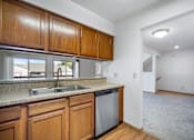 Thumbnail 30 of 60 - a kitchen with wooden cabinets and a sink and a window