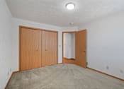 Thumbnail 10 of 60 - an empty living room with carpet and wood doors