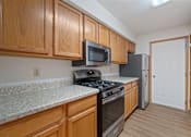 Thumbnail 2 of 60 - a kitchen with wood cabinets and granite counter tops and stainless steel appliances
