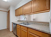 Thumbnail 3 of 60 - an empty kitchen with wooden cabinets and a stainless steel sink