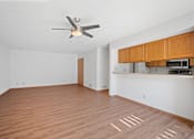 Thumbnail 5 of 60 - an empty living room with a ceiling fan and a kitchen