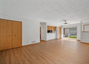 Thumbnail 4 of 60 - an empty living room with wood floors and white walls