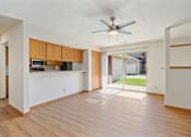 Thumbnail 6 of 60 - an empty living room with a ceiling fan and a kitchen