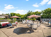 Thumbnail 25 of 60 - a patio with tables chairs and umbrellas and a pool