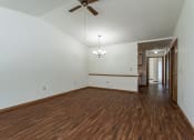 Thumbnail 14 of 19 - an empty living room with wood flooring and a ceiling fan