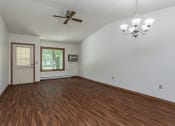 Thumbnail 6 of 19 - an empty living room with wooden floors and a ceiling fan