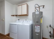 Thumbnail 17 of 19 - a small laundry room with a washer and dryer and a water heater
