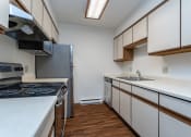 Thumbnail 2 of 19 - a kitchen with white countertops and a stainless steel refrigerator