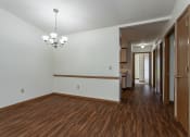 Thumbnail 4 of 19 - an empty living room and hallway with wood flooring and white walls
