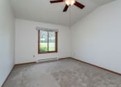 Thumbnail 8 of 19 - an empty living room with a ceiling fan and a window
