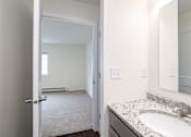 Thumbnail 66 of 69 - a bathroom with a sink and a mirror and an open door to a bedroom