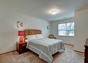 Thumbnail 43 of 44 - A bedroom with a bed, nightstand, and window.