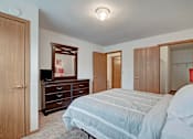Thumbnail 41 of 44 - A bedroom with a bed, dresser, and mirror.