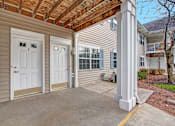 Thumbnail 8 of 44 - A house with a covered patio area has a white door and a window.