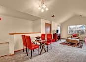Thumbnail 28 of 44 - A living room with red chairs and a grey carpet.