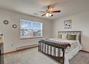 Thumbnail 42 of 44 - A bedroom with a large bed and a ceiling fan.