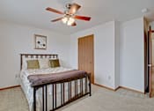 Thumbnail 40 of 44 - A bedroom with a bed, a ceiling fan, and a picture on the wall.