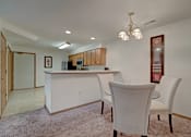 Thumbnail 25 of 44 - A kitchen with white cabinets and a white island with a microwave on top.