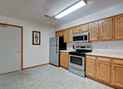 Thumbnail 22 of 44 - A kitchen with wooden cabinets and a black stove top oven.