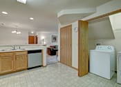 Thumbnail 29 of 44 - A kitchen with a white tiled floor and a white washing machine.
