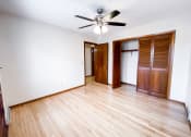 Thumbnail 26 of 27 - an empty living room with wooden floors and a ceiling fan