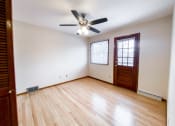 Thumbnail 18 of 27 - an empty living room with wooden floors and a ceiling fan