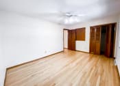 Thumbnail 24 of 27 - an empty living room with wooden floors and a ceiling fan