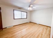 Thumbnail 19 of 27 - an empty living room with wood floors and a ceiling fan