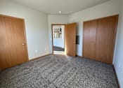 Thumbnail 19 of 34 - A room with a grey carpet and wooden doors.
