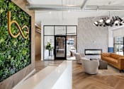 Thumbnail 1 of 21 - A modern living room with a green wall and a white floor.