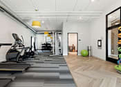 Thumbnail 20 of 21 - A gym with treadmills and exercise equipment.