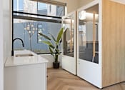 Thumbnail 17 of 21 - A modern kitchen with a white counter and a sink.