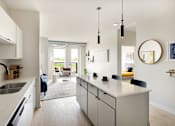 Thumbnail 2 of 21 - A modern kitchen with white cabinets and a large island.