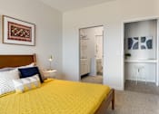Thumbnail 9 of 21 - A bedroom with a yellow bedspread and a white dresser.