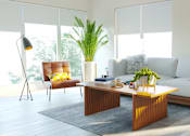 Thumbnail 13 of 21 - A modern living room with a white sofa, a wooden coffee table, and a red chair.