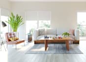 Thumbnail 14 of 21 - A modern living room with a white sofa, a wooden coffee table, and a TV on a cabinet.