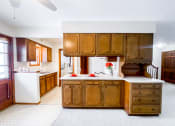 Thumbnail 10 of 27 - a kitchen with wooden cabinets and a white counter top