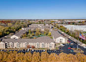 Thumbnail 8 of 43 - An aerial view of a large building complex with a parking lot in front.