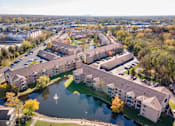 Thumbnail 7 of 43 - A large building complex with a pond in the foreground.