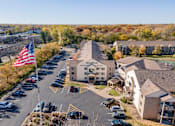 Thumbnail 9 of 43 - A parking lot with a building and an American flag in the foreground.