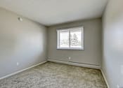 Thumbnail 21 of 31 - A room with a window and carpeted floor.