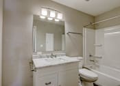 Thumbnail 28 of 31 - A bathroom with a white toilet, sink, and bathtub.